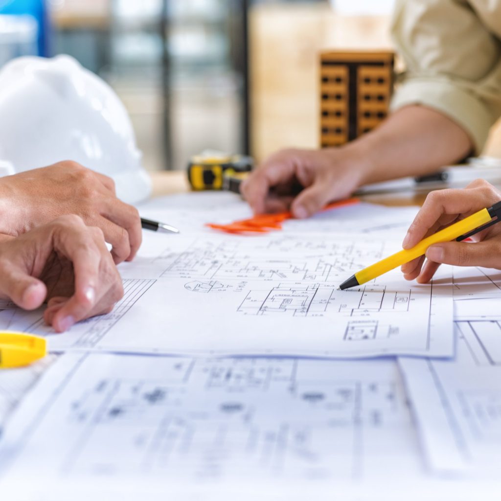 Image of team engineer checks construction blueprints on new project with engineering tools at desk in office.